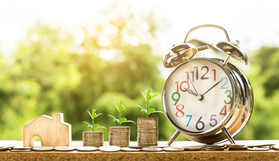 Growing property investments with clock and plant symbols representing market timing.