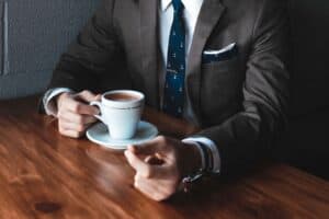 A businessman in a suit holding a coffee cup, symbolizing professionalism and modern work environmen.